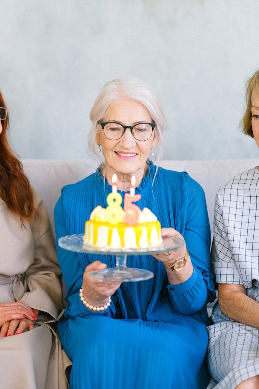 photo of an elderly woman carrying birthday cake
