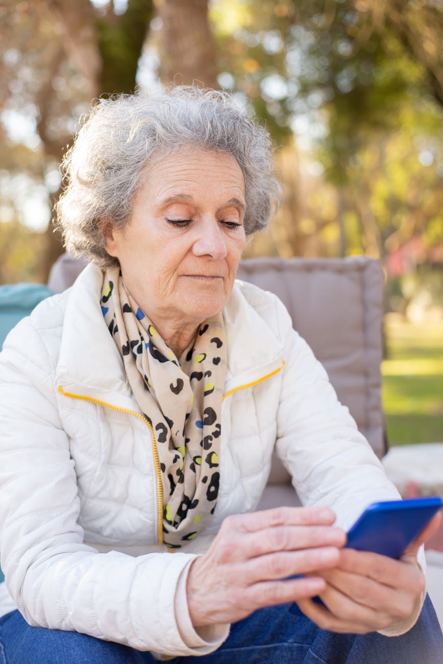 an elderly woman looking at the screen of her cellphone